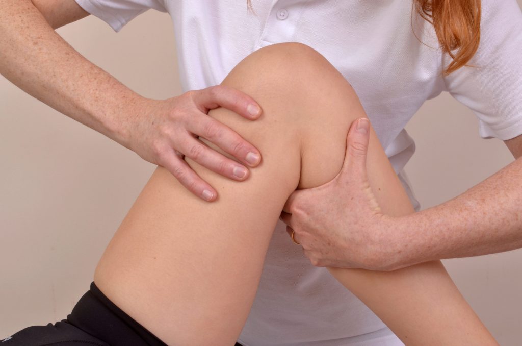 Person holding clients knee